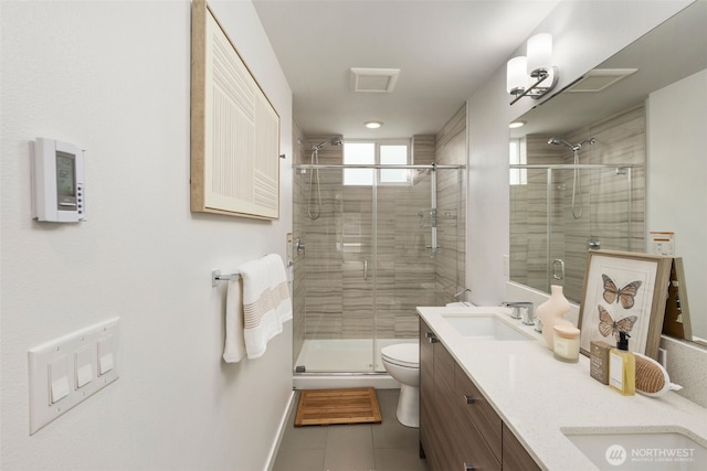 full bath with a shower stall, toilet, double vanity, tile patterned floors, and a sink