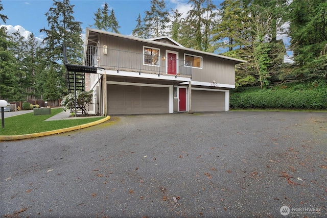 multi unit property with stairway, gravel driveway, and an attached garage