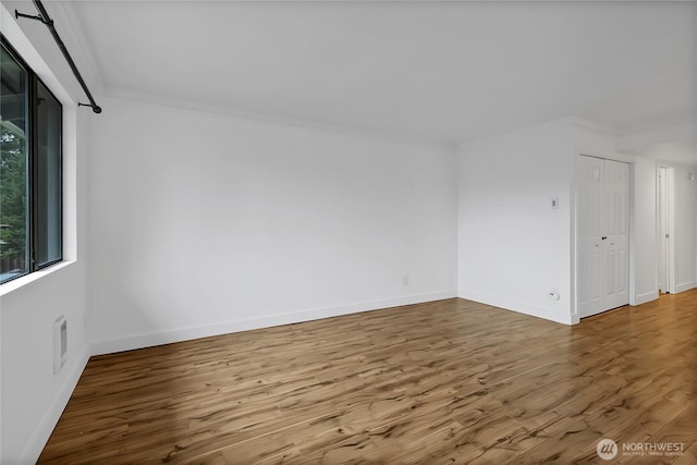 unfurnished room featuring baseboards and wood finished floors