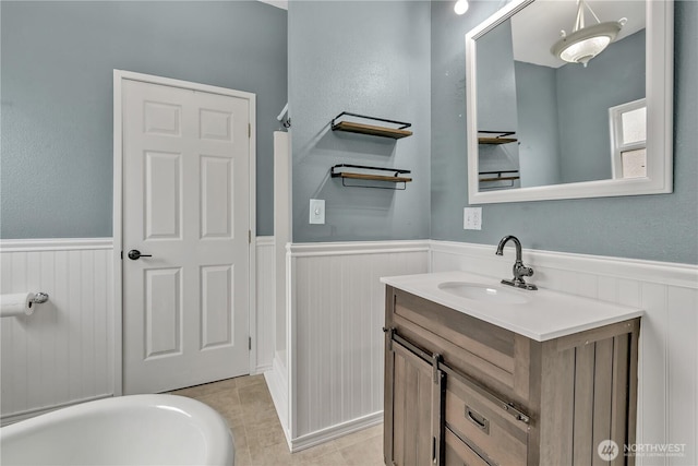 bathroom with tile patterned floors, a wainscoted wall, and vanity