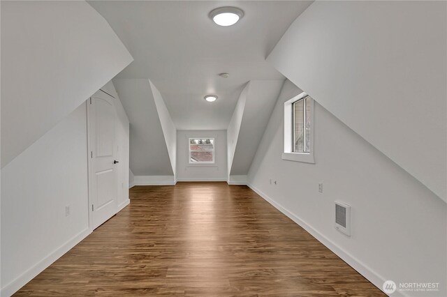 bonus room with visible vents, baseboards, and dark wood-style flooring