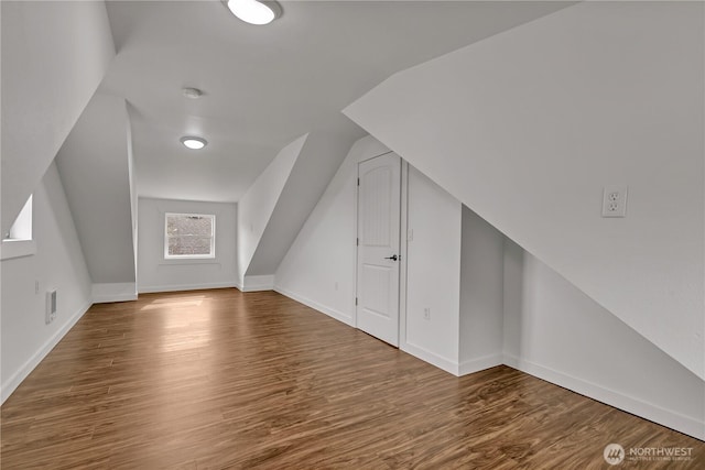 bonus room featuring visible vents, baseboards, lofted ceiling, and wood finished floors