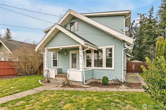 view of front of home with a front yard and fence