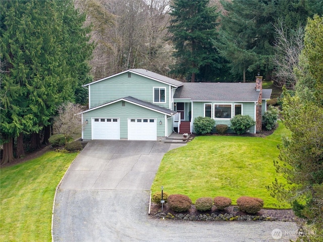 tri-level home featuring driveway, a chimney, and a front lawn