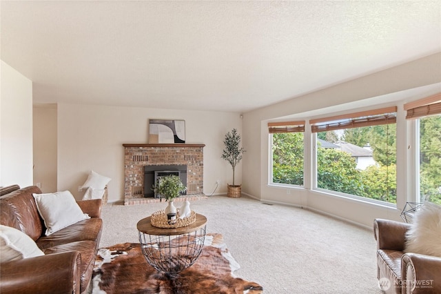 living area featuring carpet flooring, a healthy amount of sunlight, a brick fireplace, and a textured ceiling