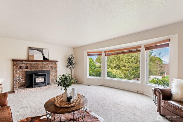 living area featuring baseboards, a textured ceiling, and carpet