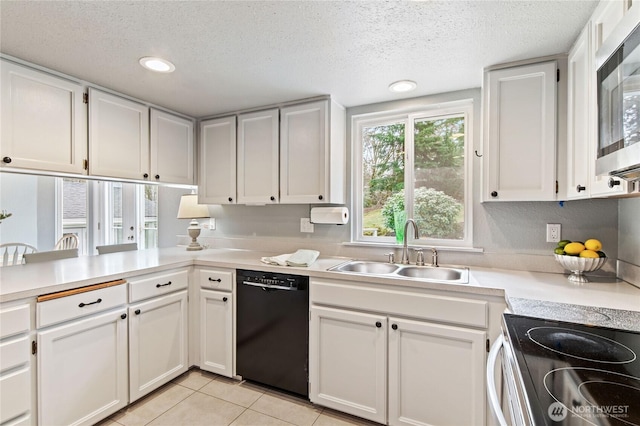 kitchen featuring light tile patterned floors, a sink, light countertops, dishwasher, and stainless steel microwave