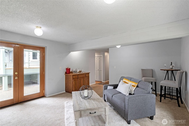 living room with baseboards, french doors, a textured ceiling, and carpet