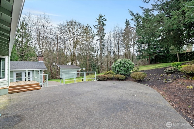 view of patio / terrace featuring a deck, an outbuilding, and a storage shed