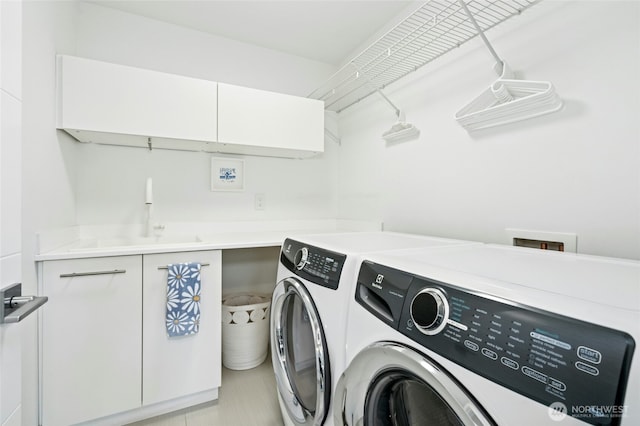 washroom featuring washer and dryer, cabinet space, and a sink