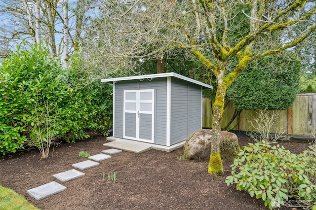 view of shed featuring fence