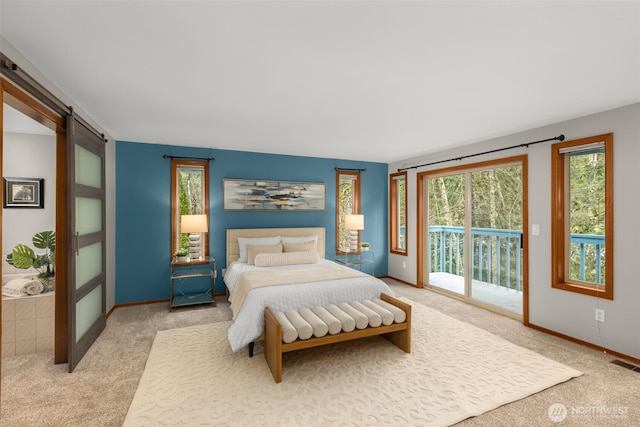 carpeted bedroom featuring a barn door, access to outside, baseboards, and visible vents