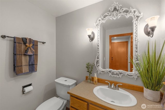 half bathroom with vanity and toilet