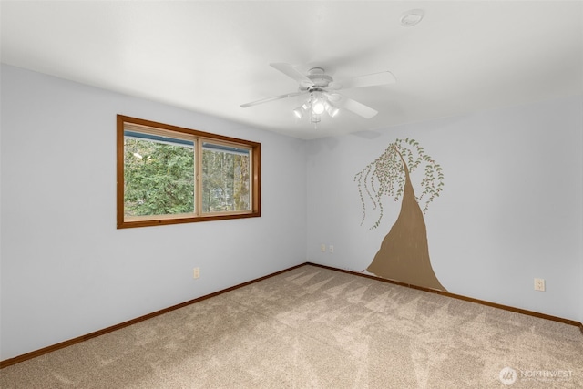 carpeted empty room with ceiling fan and baseboards