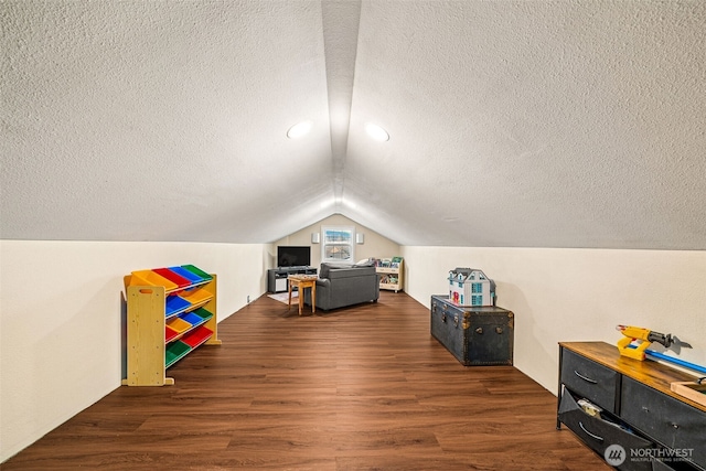 game room featuring lofted ceiling, a textured ceiling, and wood finished floors