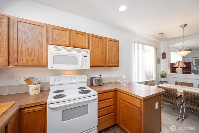 kitchen featuring pendant lighting, recessed lighting, white appliances, a peninsula, and light countertops