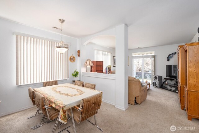 dining space featuring light carpet, visible vents, and baseboards