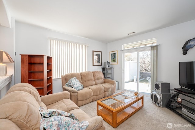 living area with visible vents and carpet floors