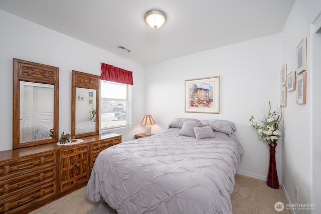 carpeted bedroom with visible vents and baseboards