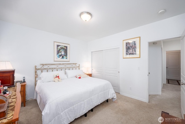 carpeted bedroom featuring baseboards and a closet