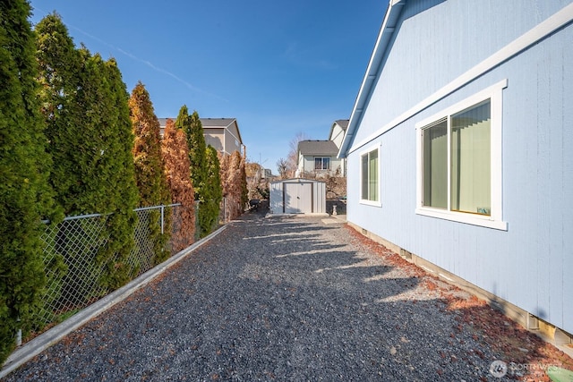 exterior space featuring an outdoor structure, a storage unit, and fence