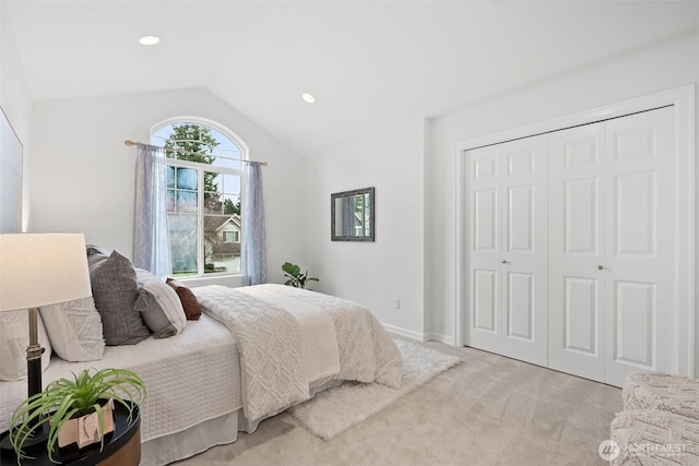 bedroom with recessed lighting, a closet, baseboards, light colored carpet, and vaulted ceiling