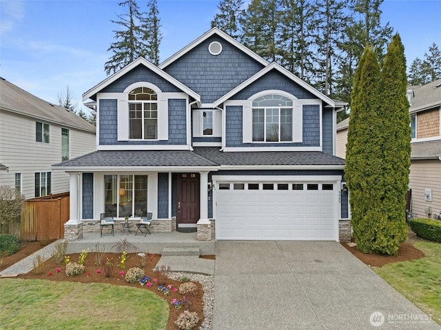 craftsman inspired home with stone siding, a porch, concrete driveway, and an attached garage