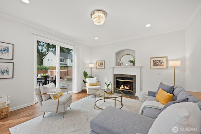 living room featuring baseboards, wood finished floors, and ornamental molding