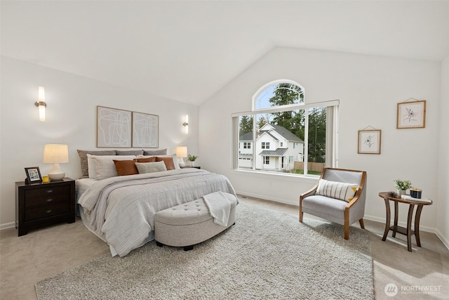 bedroom featuring baseboards, light colored carpet, and vaulted ceiling