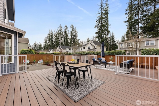 wooden terrace with outdoor dining area, a residential view, and fence