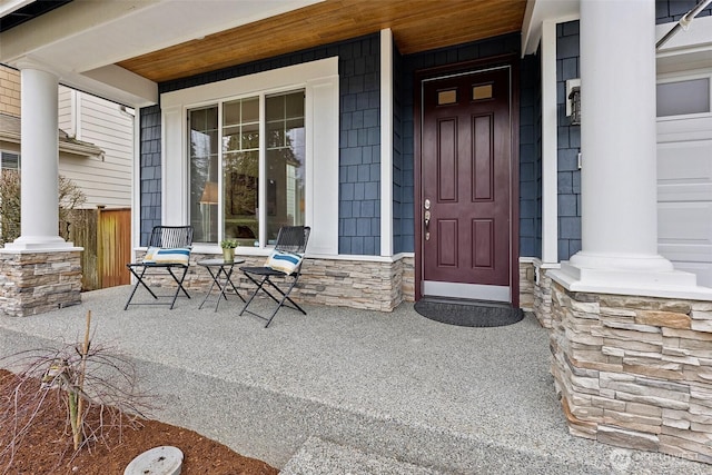 doorway to property featuring covered porch and stone siding