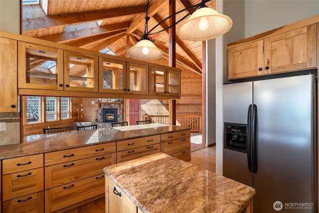 6065 Central Ave, Anacortes, WA 98221 - kitchen featuring stainless steel fridge with ice dispenser, lofted ceiling with beams, glass insert cabinets, light stone countertops, and a peninsula