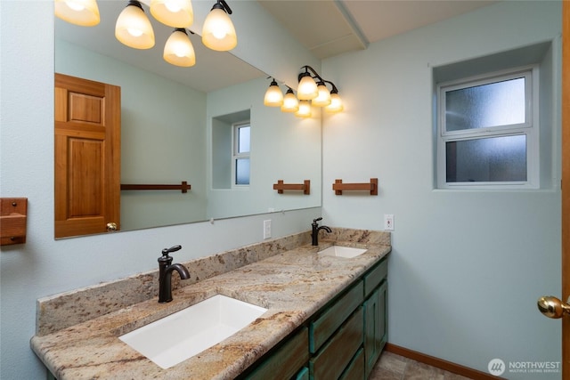 6065 Central Ave, Anacortes, WA 98221 - bathroom featuring a chandelier, double vanity, baseboards, and a sink