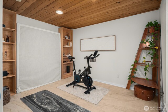 exercise area with baseboards, wood ceiling, and wood finished floors