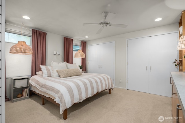 bedroom featuring light carpet, recessed lighting, two closets, and ceiling fan