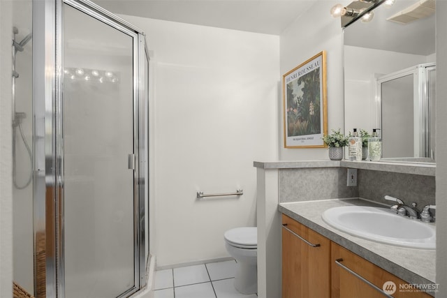 bathroom with tile patterned floors, toilet, and a stall shower