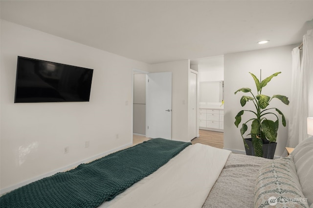 bedroom featuring recessed lighting, ensuite bathroom, baseboards, and wood finished floors