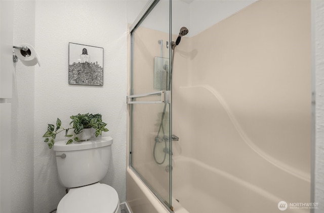 full bathroom with toilet and combined bath / shower with glass door