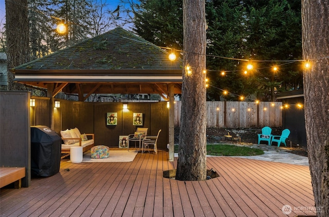 wooden terrace featuring a gazebo, fence, and a grill