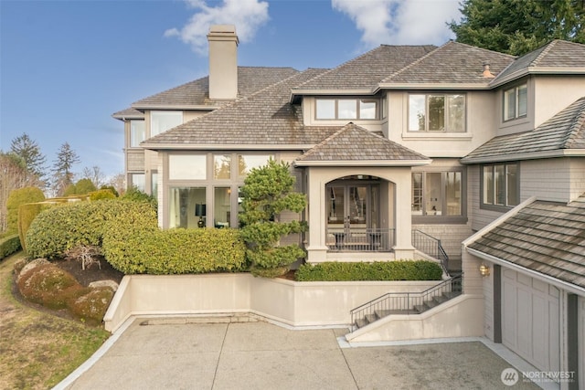 back of property featuring stucco siding, a chimney, and french doors