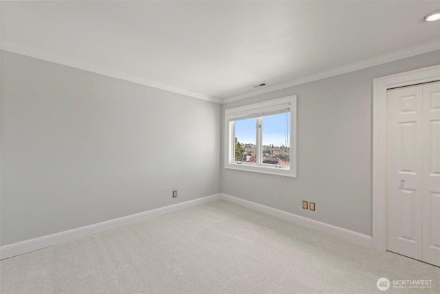 unfurnished room featuring baseboards, light carpet, visible vents, and crown molding