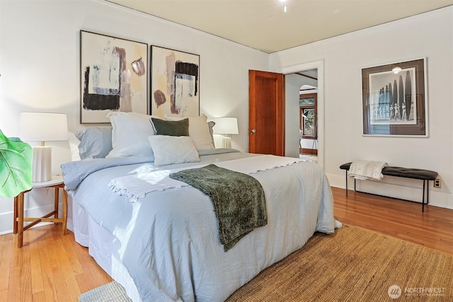 bedroom with light wood-type flooring and baseboards