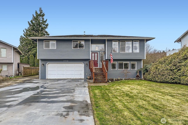 bi-level home with a front yard, an attached garage, and driveway