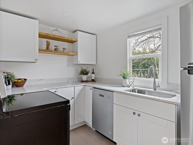 kitchen with a sink, open shelves, stainless steel appliances, white cabinets, and light countertops