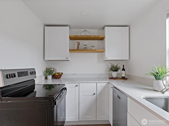 kitchen with light countertops, white cabinets, open shelves, and appliances with stainless steel finishes