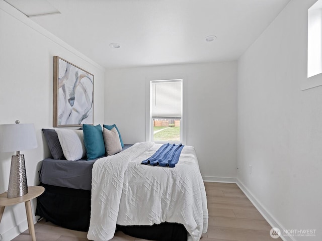 bedroom with light wood-type flooring and baseboards