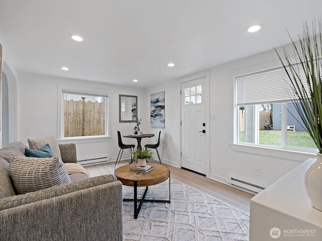 living area with a baseboard heating unit, recessed lighting, and light wood-style floors