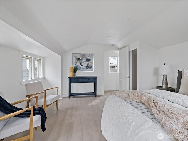 bedroom with baseboards, multiple windows, light wood-style flooring, and vaulted ceiling