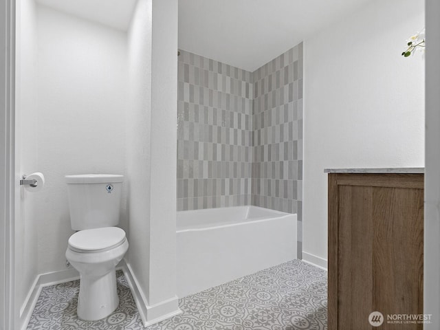 bathroom featuring tile patterned floors, toilet, baseboards, and shower / washtub combination