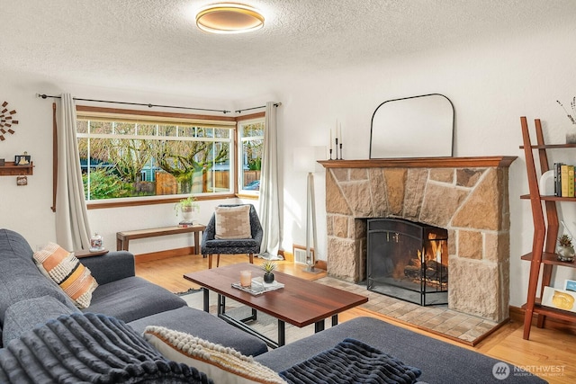 living area featuring a fireplace, wood finished floors, visible vents, and a textured ceiling